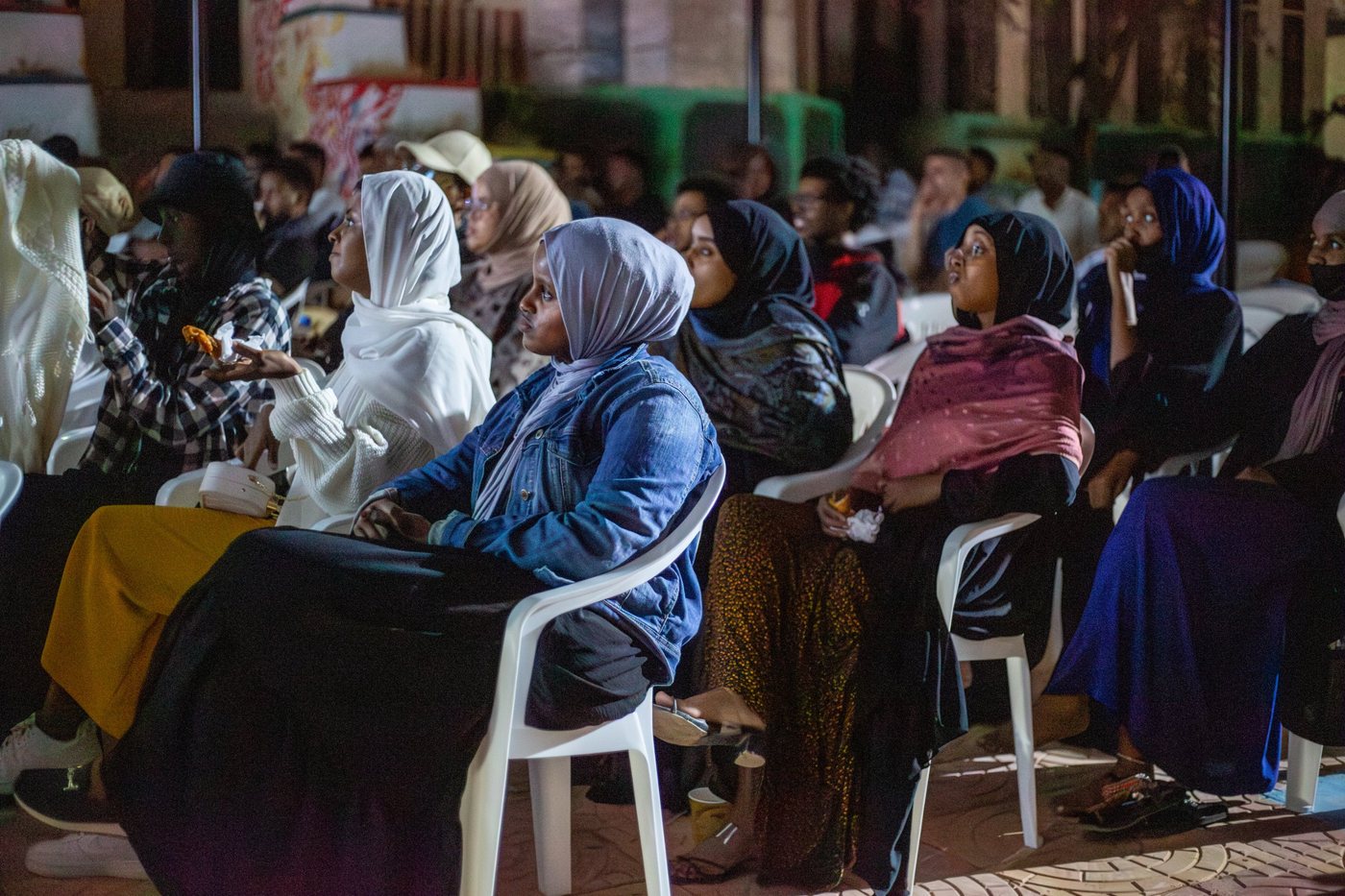 Women in the audience follow a film
