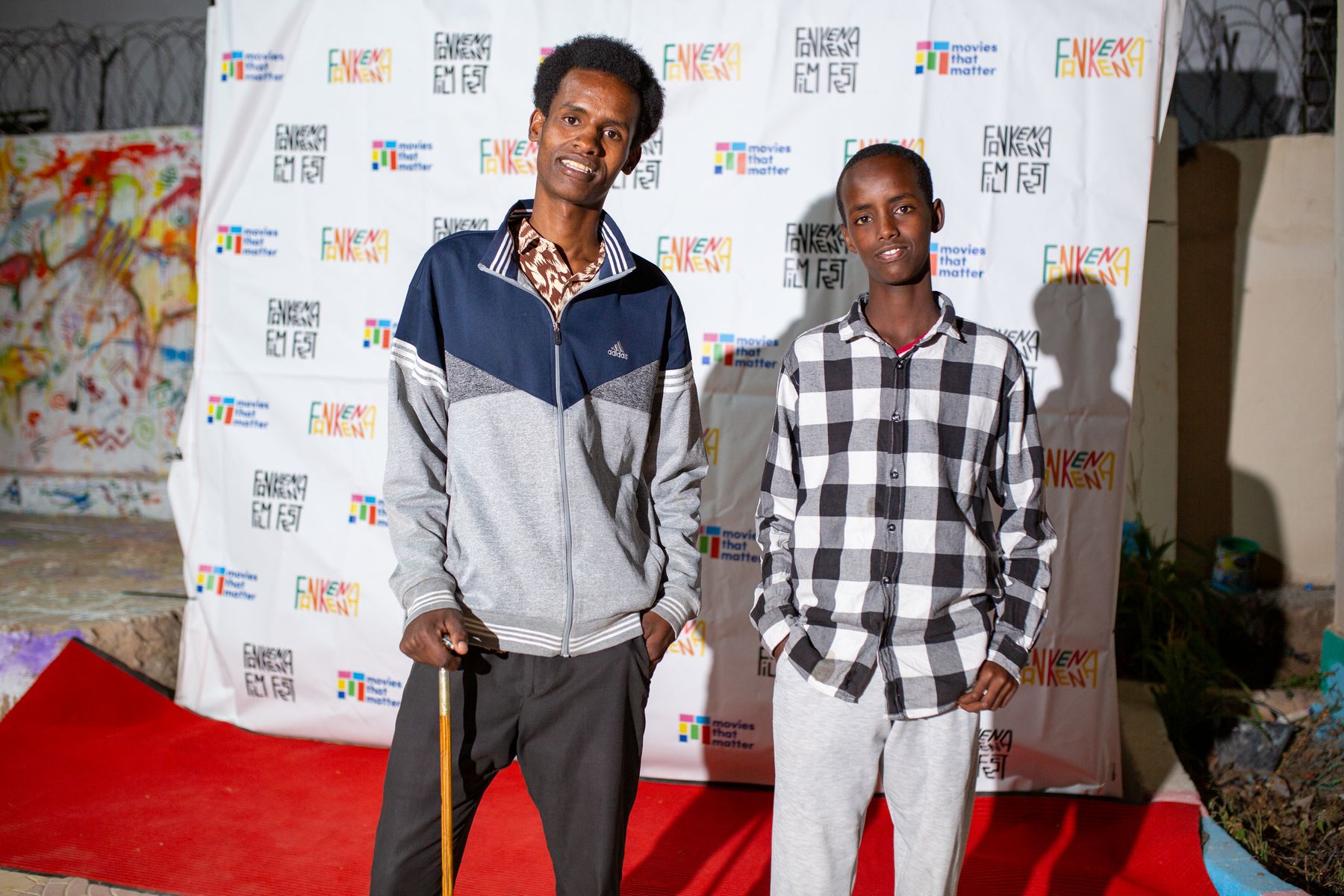 Two guests on the red carpet in front of the festival wall