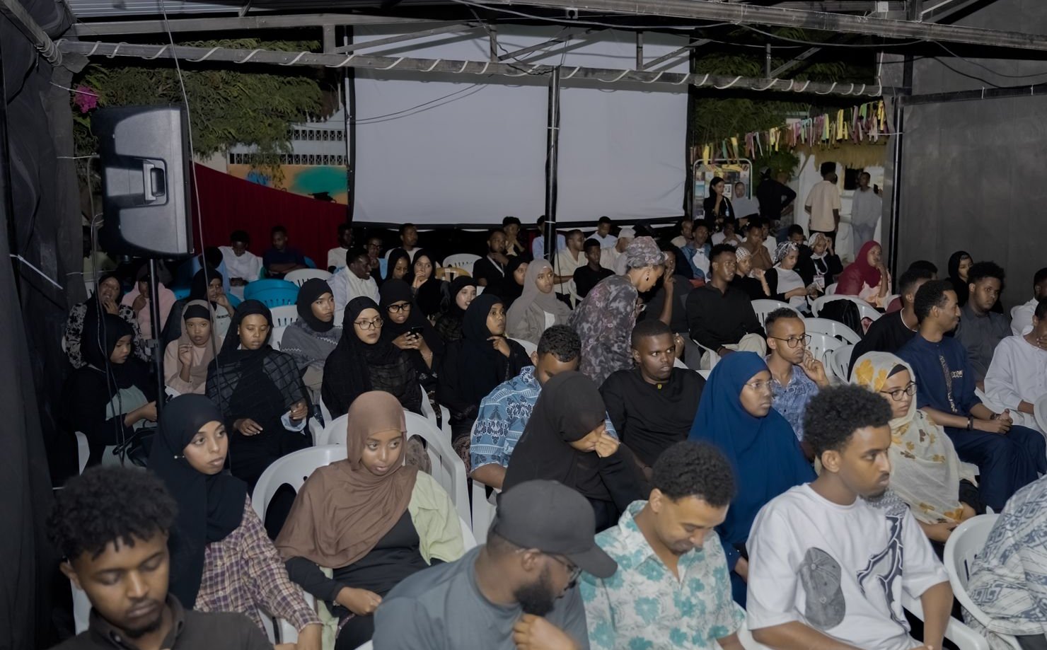 A packed audience under the courtyard roof in 2025