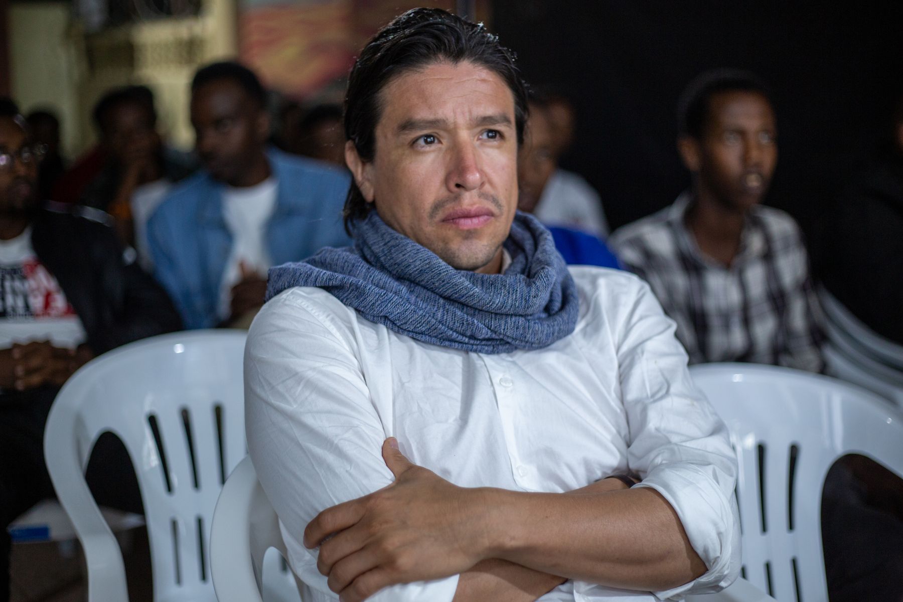 A guest watches the screening with his arms crossed